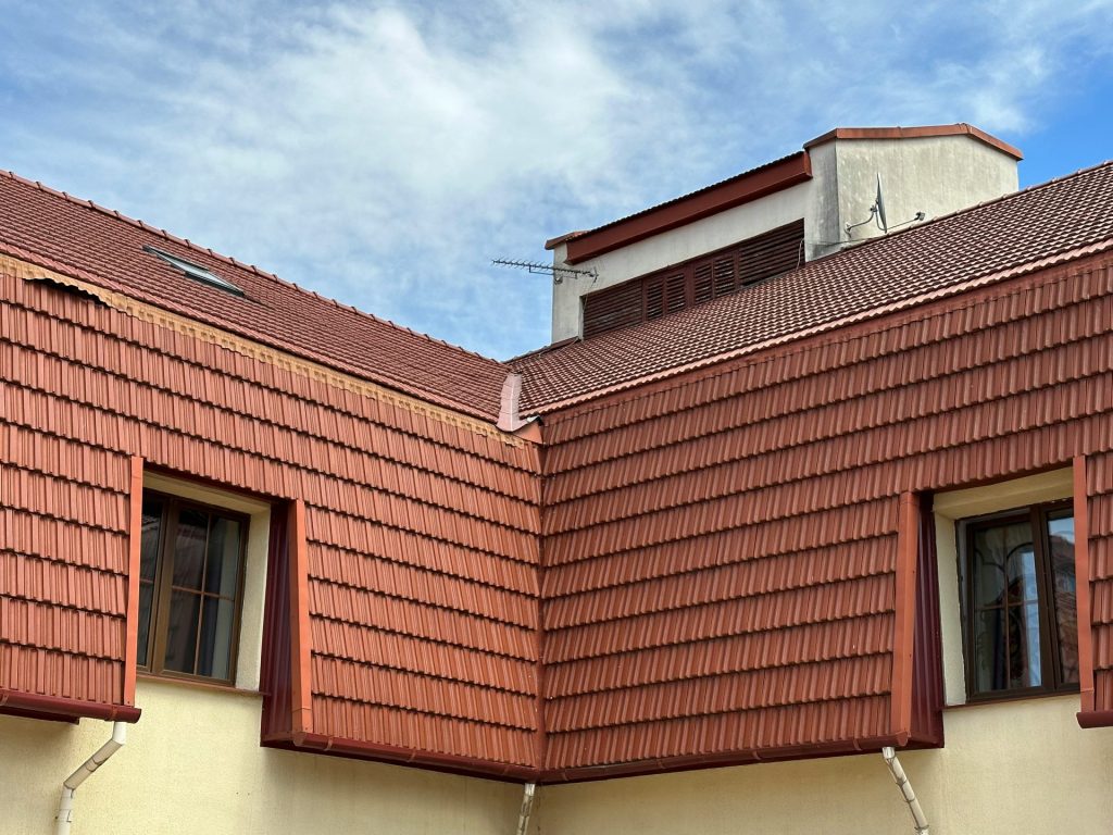 a red roof with two windows and a sky background